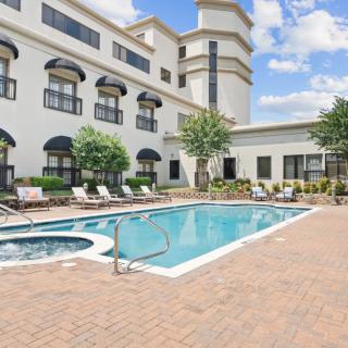 A tranquil outdoor swimming pool area at a hotel, perfect for relaxation on a sunny day.