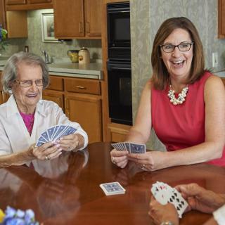 A group of people are enjoying a card game together in a kitchen setting.