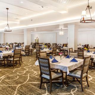 A spacious and elegantly decorated dining room with several tables set for a meal.