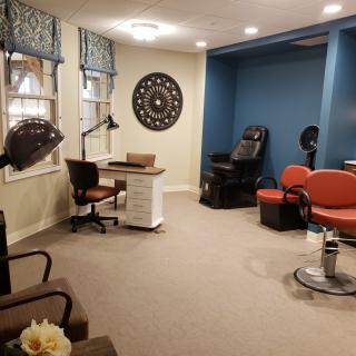 A cozy and well-decorated salon interior with comfortable seating and beauty stations.
