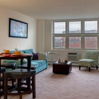 A cozy living room with a comfortable couch, dining table, and large windows.