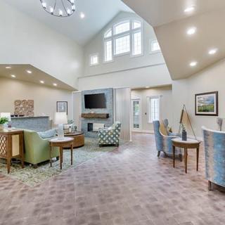 A spacious and well-lit living room with modern furniture and a vaulted ceiling.