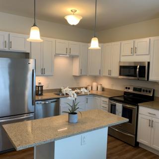 A modern kitchen with stainless steel appliances and an island.