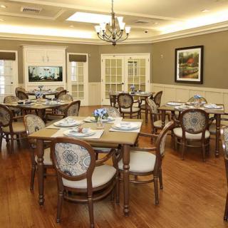 An elegantly designed dining room with wooden furniture and a chandelier.