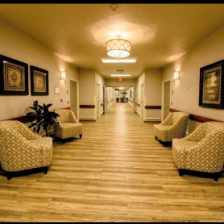 A well-lit corridor featuring patterned chairs and decorative wall art.