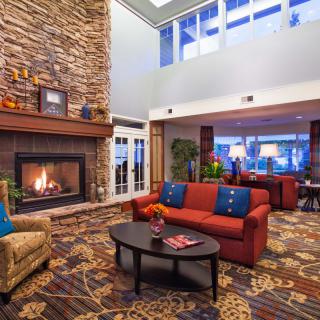 A cozy hotel lobby featuring a warm fireplace and comfortable seating area.