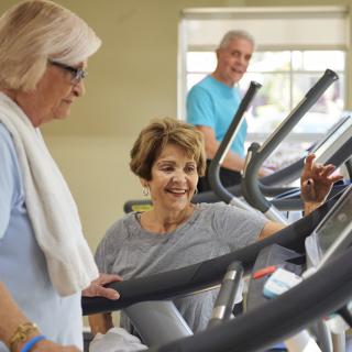 Seniors enjoying a workout together on treadmills at the gym.