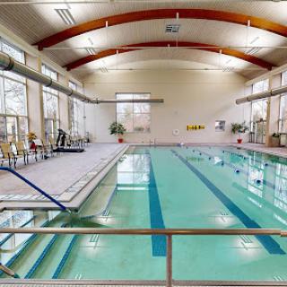 A spacious indoor swimming pool equipped for recreation and fitness activities.
