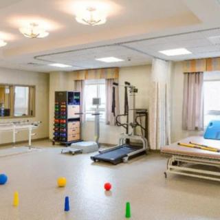 A well-equipped rehabilitation room with exercise machines and therapy aids.