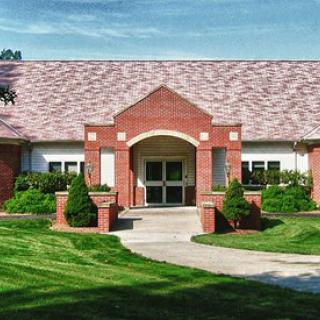 A welcoming brick building with a landscaped entrance.