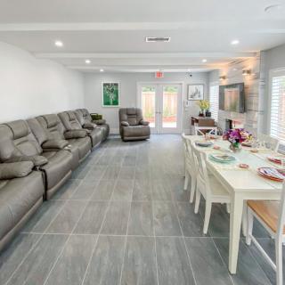 A modern living room with a spacious open layout featuring comfortable sofas and a dining table.
