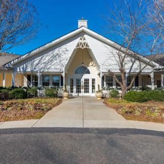 Front view of a building with a peaked roof and landscaped surroundings.