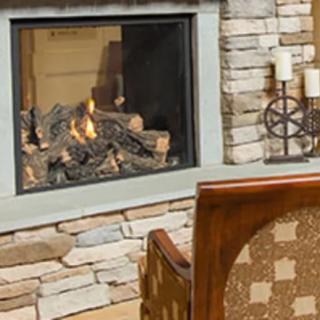 A cozy room with a stone fireplace and comfortable seating.
