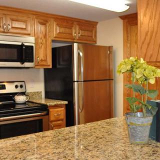 A modern kitchen featuring wooden cabinets and stainless steel appliances.