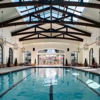 A beautifully designed indoor swimming pool with ample natural light and elegant architectural features.