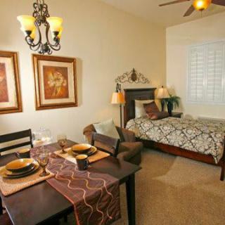 A cozy studio apartment featuring a neatly arranged bedroom and dining area.