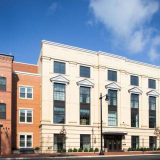 A modern urban building with classic architectural elements on a sunny day.