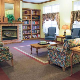 A cozy living room with a fireplace, bookshelves, and comfortable seating.