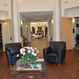 A welcoming lobby area with leather chairs and a table decorated with flowers.