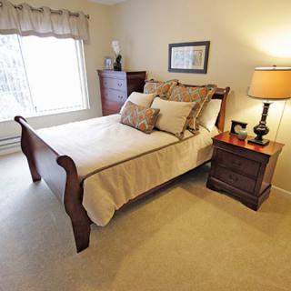A cozy bedroom with wooden furniture and warm lighting.