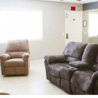 A cozy living room featuring a reclining chair and a plush sofa.