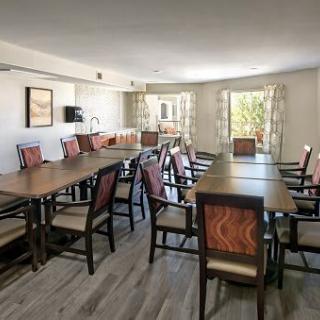 A well-lit conference room with tables and chairs arranged for a meeting.