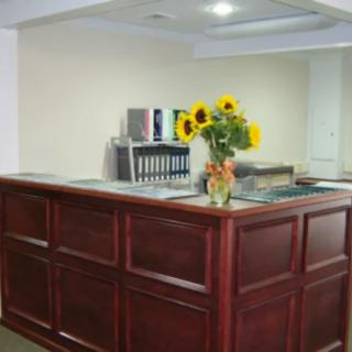 A reception desk with a vase of sunflowers in an office setting.