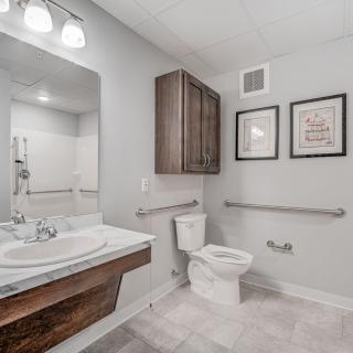 A modern bathroom with a sink, toilet, and decorative wall art.