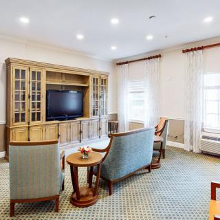 A cozy living room with comfortable seating, a large TV, and elegant decor.