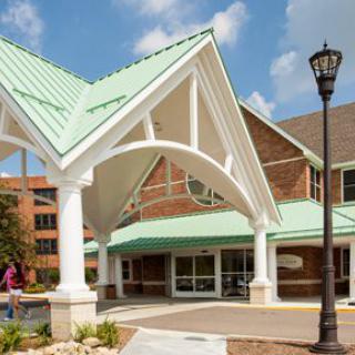 A building entrance with a green roof and white columns.