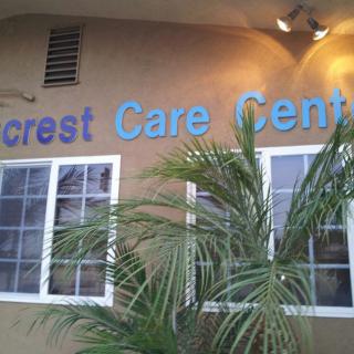 The exterior of a care center with visible signage and nearby palm tree.