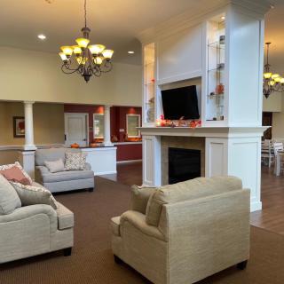 A cozy living room with comfortable sofas, a fireplace, and a wall-mounted TV.