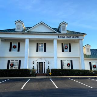 A beautiful white building with classic architectural features and a well-maintained landscape.