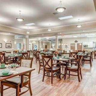 A spacious and well-lit dining area with neatly arranged tables and chairs.