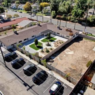 An aerial view of a building with surrounding parking and landscaped areas.