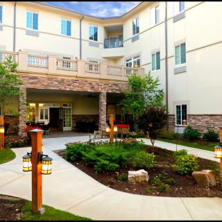 A modern residential building with a landscaped courtyard and garden pathway.