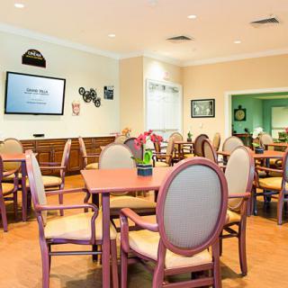 A neatly arranged dining room with tables and chairs under bright lighting.