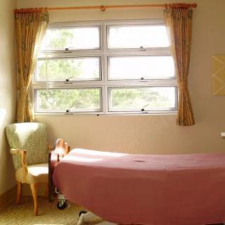 A tranquil therapy room with a massage table next to a window.