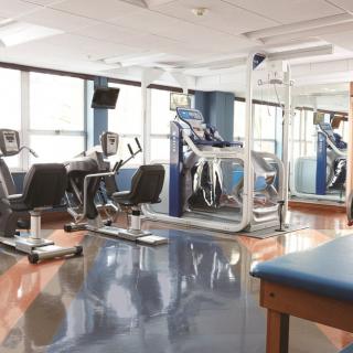 A modern gym with various exercise equipment including treadmills and stationary bikes.