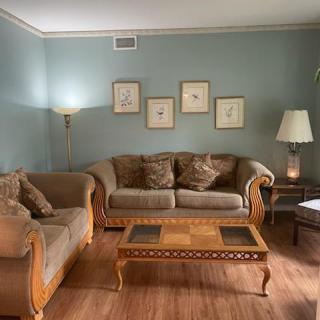 A cozy living room with a set of sofas, a wooden coffee table, and elegant wall art.