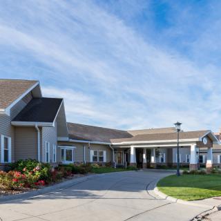 A residential building with a driveway and clear sky.