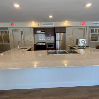 A modern kitchen with a large countertop and stainless steel appliances.