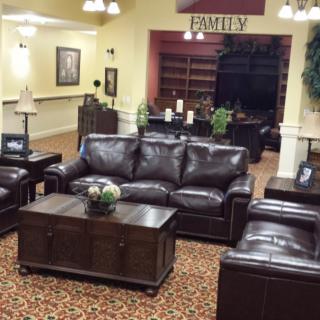 A cozy living room with leather sofas and a coffee table, decorated in a warm interior style.