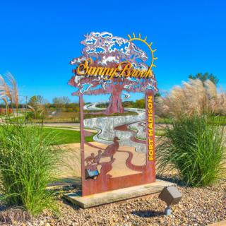 A scenic outdoor park sign under a clear blue sky.