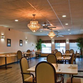 A cozy restaurant interior with elegant chandeliers and neatly arranged dining tables.