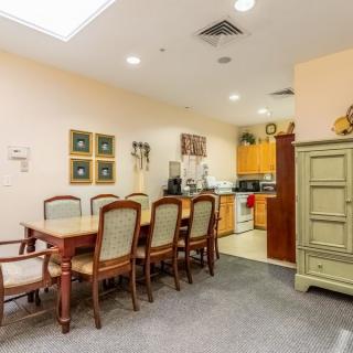 A cozy dining area with a wooden table and chairs, adjacent to a kitchen.