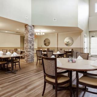 A spacious dining area with neatly arranged tables and chairs, featuring elegant interior decor.