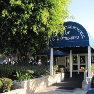 Entrance to a building with an awning labeled 'Administration', surrounded by trees and landscaping.