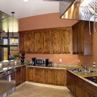 A modern kitchen featuring wooden cabinets, granite countertops, and stainless steel appliances.