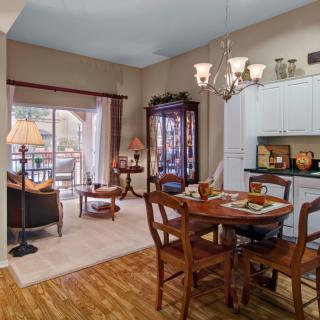 A cozy living and dining area with wooden furniture and warm lighting.
